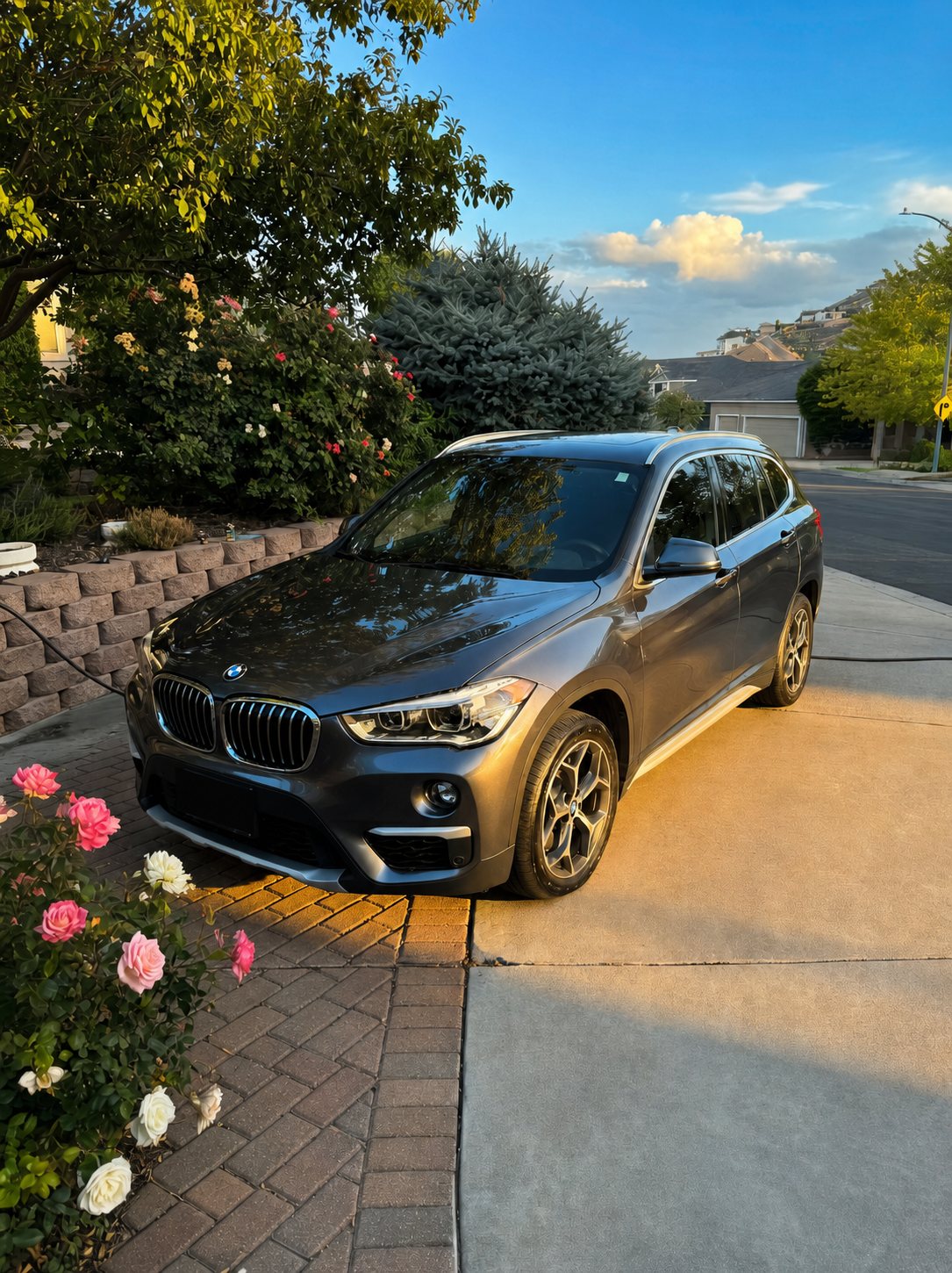 Detailed gray BMW X1 at golden hour in a Tri-Cities driveway