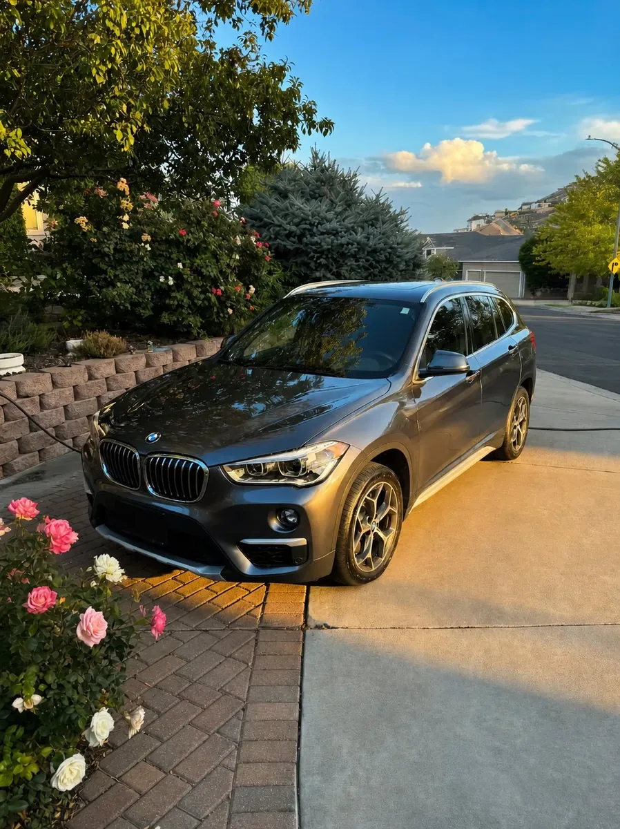 Detailed gray BMW X1 at golden hour in a Tri-Cities driveway